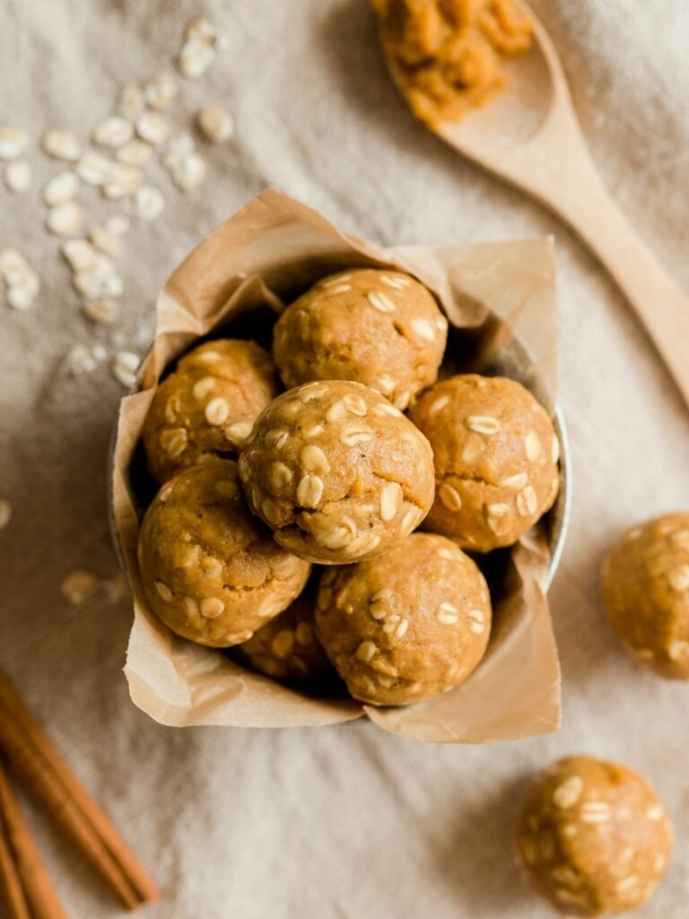 "Overhead shot of pumpkin oat cookie dough balls in a bowl, naturally sweet, vegan and gluten-free snack."