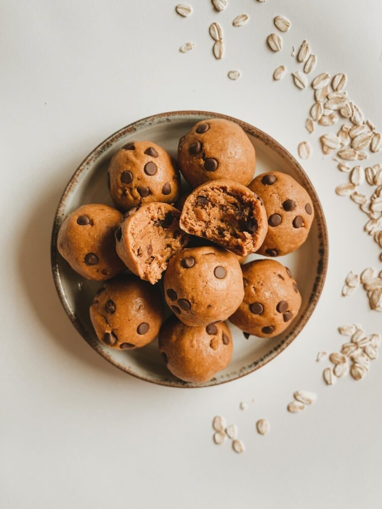 "Top-down view of soft, chewy chocolate chip pumpkin balls on a white plate, vegan and gluten-free snack."